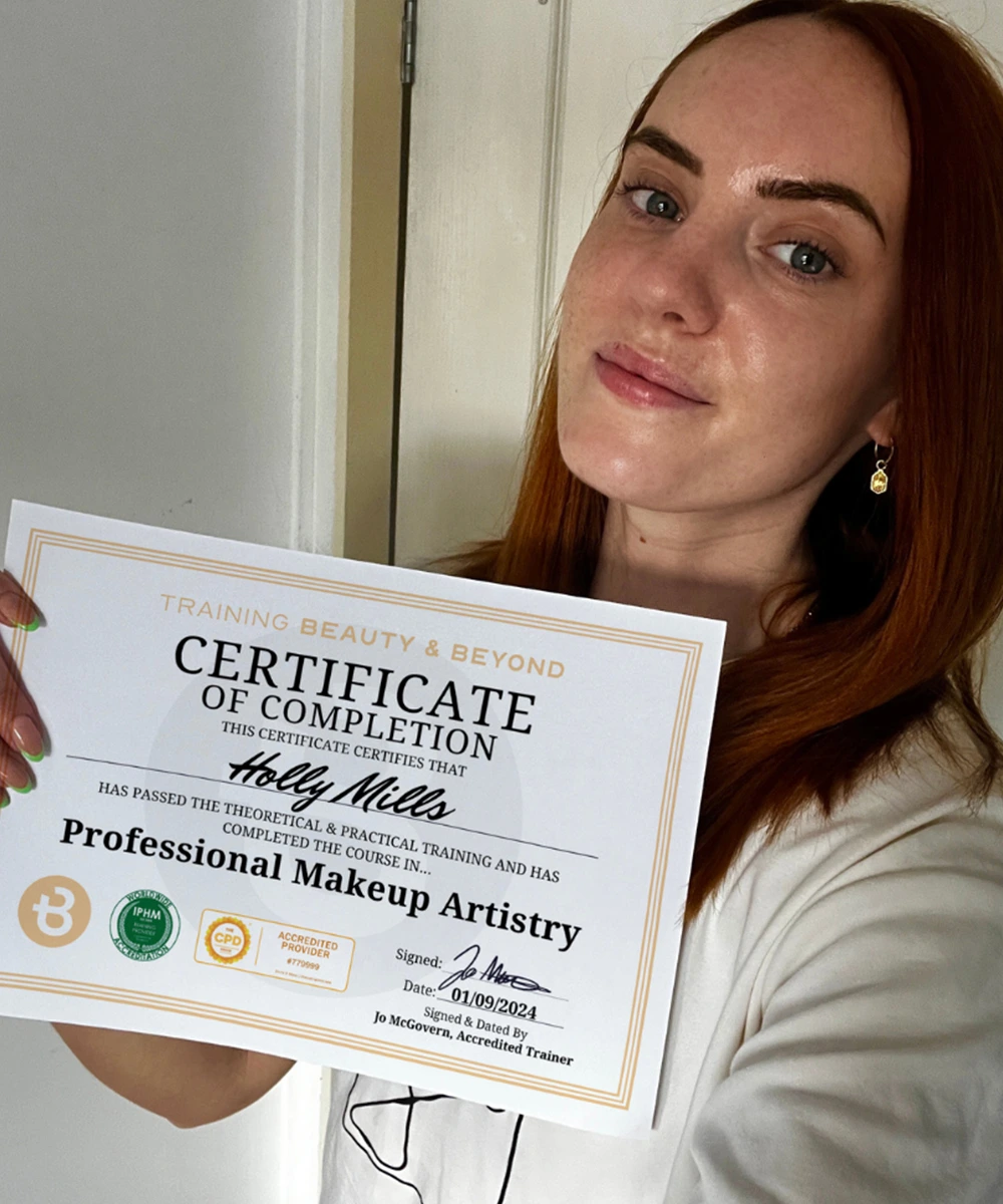 Student Holly holding makeup artistry certificate